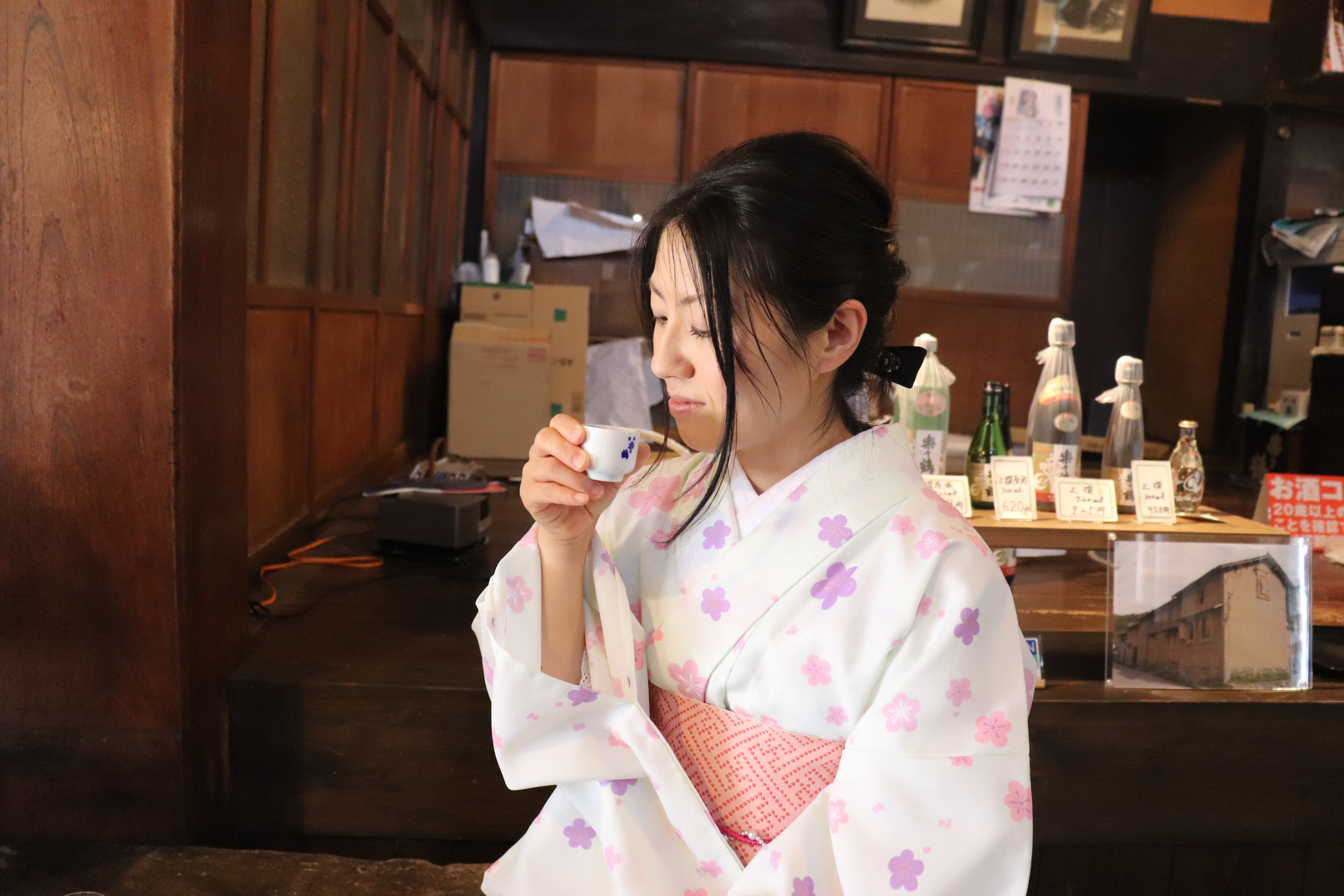 日本酒・楽々鶴を試飲する女性